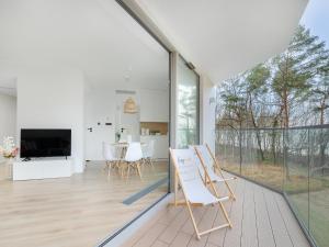 a room with glass doors and a table and chairs at Apartment in Pobierowo with Sea View in Pobierowo
