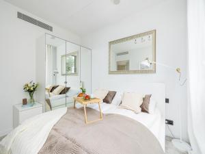 a white room with a bed and a table at Apartment in Pobierowo with Sea View in Pobierowo +26 photos