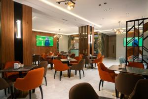 a restaurant with tables and chairs and a tv at Living Appart-Hotel in Tangier