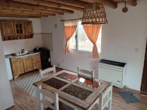a kitchen with a table in the middle of a room at Alojamiento Küme Kiyen in Aluminé