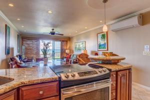 a kitchen with a stove top oven next to a living room at A9 Direct Oceanfront 2 Level 2 Lanai Amazing Views Sunsets & AC Comfort in Lahaina