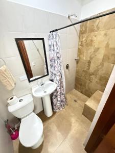 a bathroom with a toilet and a sink and a shower at hostal orquideas de auri in Necoclí