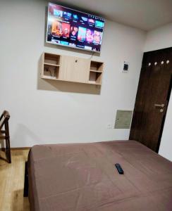 a bedroom with a bed and a flat screen tv at Hermoso Apartamento Ave Paraíso Prado in Cochabamba