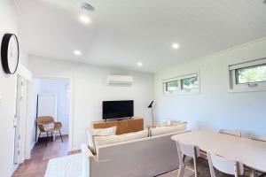 un soggiorno con un divano e un tavolo di Beautiful garden cottage in Bowral a Bowral