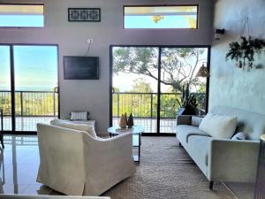 a living room with two couches and a tv at Azulita Oasis, Family-Sized Loft With Pool & Large Outdoor Areas in Aguas Zarcas