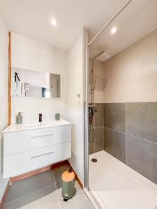 une salle de bain blanche avec une douche et un lavabo et une douche dans l'établissement APPARTEMENT "Ti CABANE" villa Bel Kay Nou, à Sainte-Luce