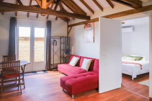 un salon avec un canapé rouge et un lit dans l'établissement APPARTEMENT "Ti CABANE" villa Bel Kay Nou, à Sainte-Luce 25 autres photos