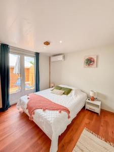 une chambre avec un lit et une grande fenêtre dans l'établissement APPARTEMENT "Ti CABANE" villa Bel Kay Nou, à Sainte-Luce