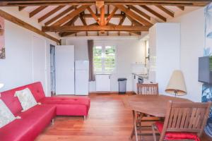 un salon avec un canapé rouge et une table en bois dans l'établissement APPARTEMENT "Ti CABANE" villa Bel Kay Nou, à Sainte-Luce