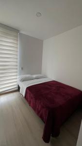 a bedroom with a large bed with a red blanket at Apartamento Urapanes cerca a home center in Manizales +9 photos
