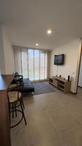 a living room with a tv and a couch and a chair at Apartamento Urapanes cerca a home center in Manizales