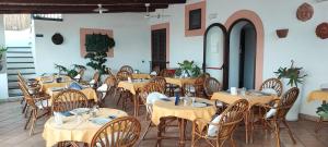 a group of tables and chairs in a restaurant at Hotel Principe di Rinella in Leni