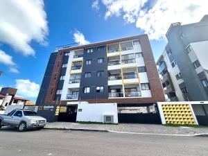 a building with a car parked in front of it at Quelônia Residence in Nossa Senhora do Livramento