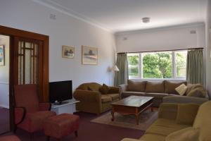 a living room with a couch and chairs and a tv at Clanwilliam in Blackheath