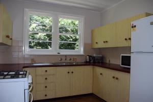 a kitchen with a sink and a white refrigerator at Clanwilliam in Blackheath