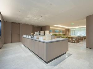 上海Ji Hotel Shanghai Pudong Airport的一个带柜台的大堂和一间餐厅