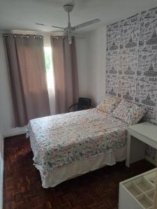 a bedroom with a bed with a floral bedspread at Apartamento MAR AZUL 2 in Vila Velha