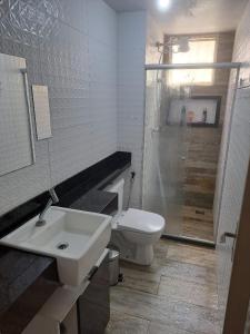 a bathroom with a toilet and a sink and a shower at Apartamento MAR AZUL 2 in Vila Velha