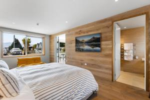 a bedroom with a large bed and wooden walls at Alp Studios Apartment 1 in Wanaka +38 photos