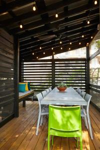 a patio with a table and chairs on a deck at Eden Brae: Historic Southern Gothic Mansion in Birmingham