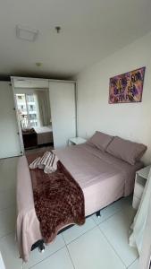 a bedroom with a large bed with a blanket on it at Taguá Life Resort - Ideal para sua estadia in Riacho Fundo