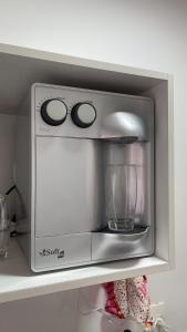 a microwave sitting on top of a shelf at Taguá Life Resort - Ideal para sua estadia in Riacho Fundo