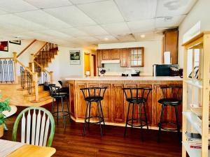 a kitchen with wooden cabinets and bar stools at Mixon villas in Waterbury