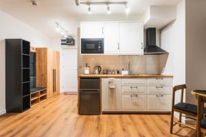 a kitchen with white cabinets and a black refrigerator at Apartament pod Gubają in Zakopane