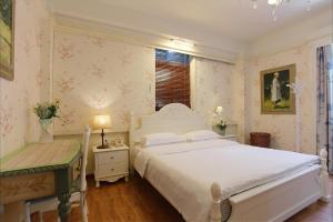Un pat sau paturi într-o cameră la Gulangyu Baiju Monet Garden Coffee Music Villa