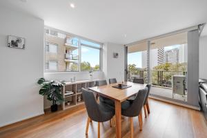 キャンベラにあるStylish 1-Bed Flat with Pool BBQ & Sauna Accessのテーブルと椅子付きのアパートメントダイニングルーム