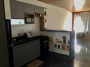 una piccola cucina con lavello e forno a microonde di Aconchego a Maceió