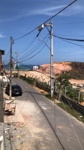 una strada con un'auto parcheggiata sul ciglio della strada di Aconchego a Maceió