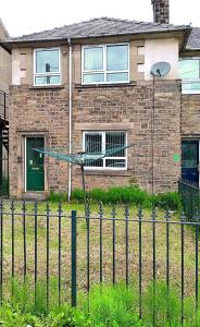 a brick house with a fence in front of it at YPCC Hardaker Street in Bradford
