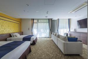 a hotel room with two beds and a couch at WeBase KAMAKURA in Kamakura