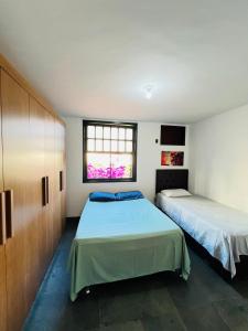 a bedroom with two beds and a window at Village prainha in Arraial do Cabo