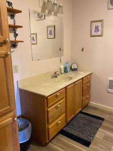 a bathroom with a sink and a mirror at Cozy Log Home across from Phillips Lake-Four Season Fun in Dedham +70 photos