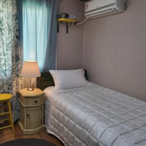 een kleine slaapkamer met een bed en een lamp bij Gwangan Beach Cozy House in Busan