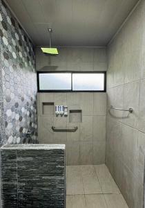 a bathroom with a large shower with a window at Hidden River Lodge & Termales Incluidas in San Francisco +20 photos
