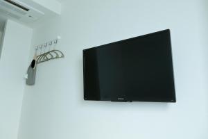 a flat screen tv on a wall with a pair of scissors at Hotel Nupka in Obihiro