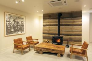 a living room with a fireplace and a table and chairs at Hotel Nupka in Obihiro
