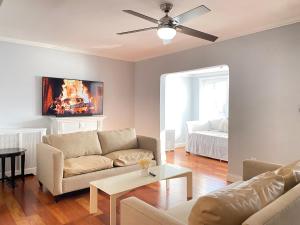 a living room with a couch and a ceiling fan at Best XL Home To Visit NYC+Hot Tub+Newark Airport+Free Parking in Hillside