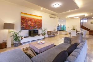 a living room with a couch and a tv at Dragonville 3BR Private Pool Canggu Residence CYN in Mantaak