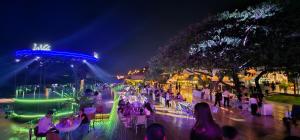 a group of people sitting at tables at night at Apartment Condo Guest house Near Mekong River in Phnom Penh in Phnom Penh