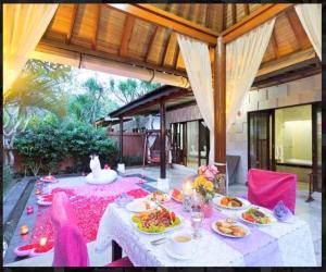 a dining table with plates of food on it at Classic Villa with Private Pool in Kuta