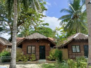 a house with palm trees in front of it at Panglao Grande Resort 邦劳美丽度假村 in Panglao Island