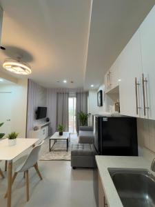 a kitchen and living room with a couch and a table at Alder - One Bedroom Condo Unit with Balcony in Davao City