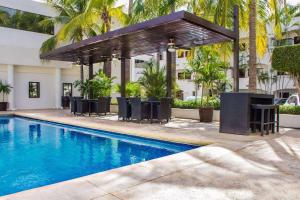 a pool with chairs and a pavilion next to a building at Wyndham Garden Los Mochis Plaza Inn in Los Mochis