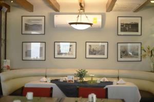 a dining room with two tables and a couch at Wyndham Garden Los Mochis Plaza Inn in Los Mochis