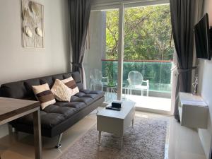 a living room with a couch and a large window at Emerald Terrace Condo 10-Family One Bed & Sofa Bed Garden View in Patong Beach
