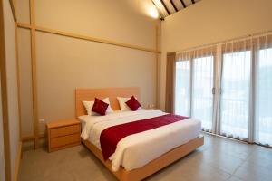a bedroom with a large bed with red pillows at Wanaseta Guesthouse in Uluwatu +13 photos